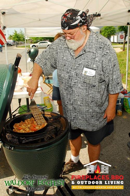 man cooking on big green egg