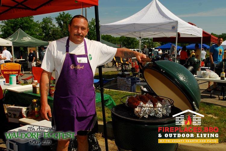 man in purple apron with big green egg