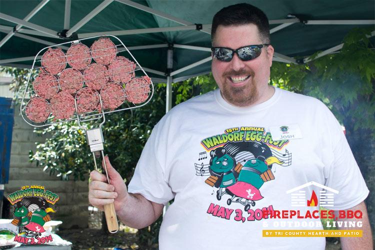 man at Egg Fest holding racks of meat
